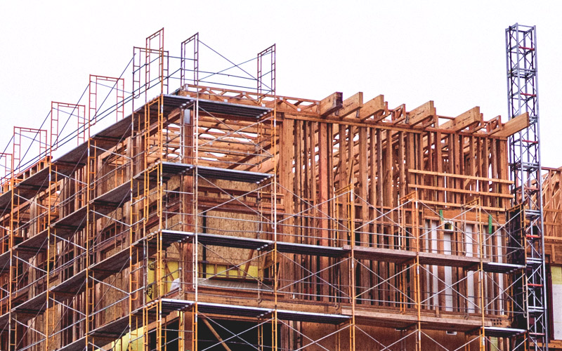Timber-framed building under construction with scaffolding